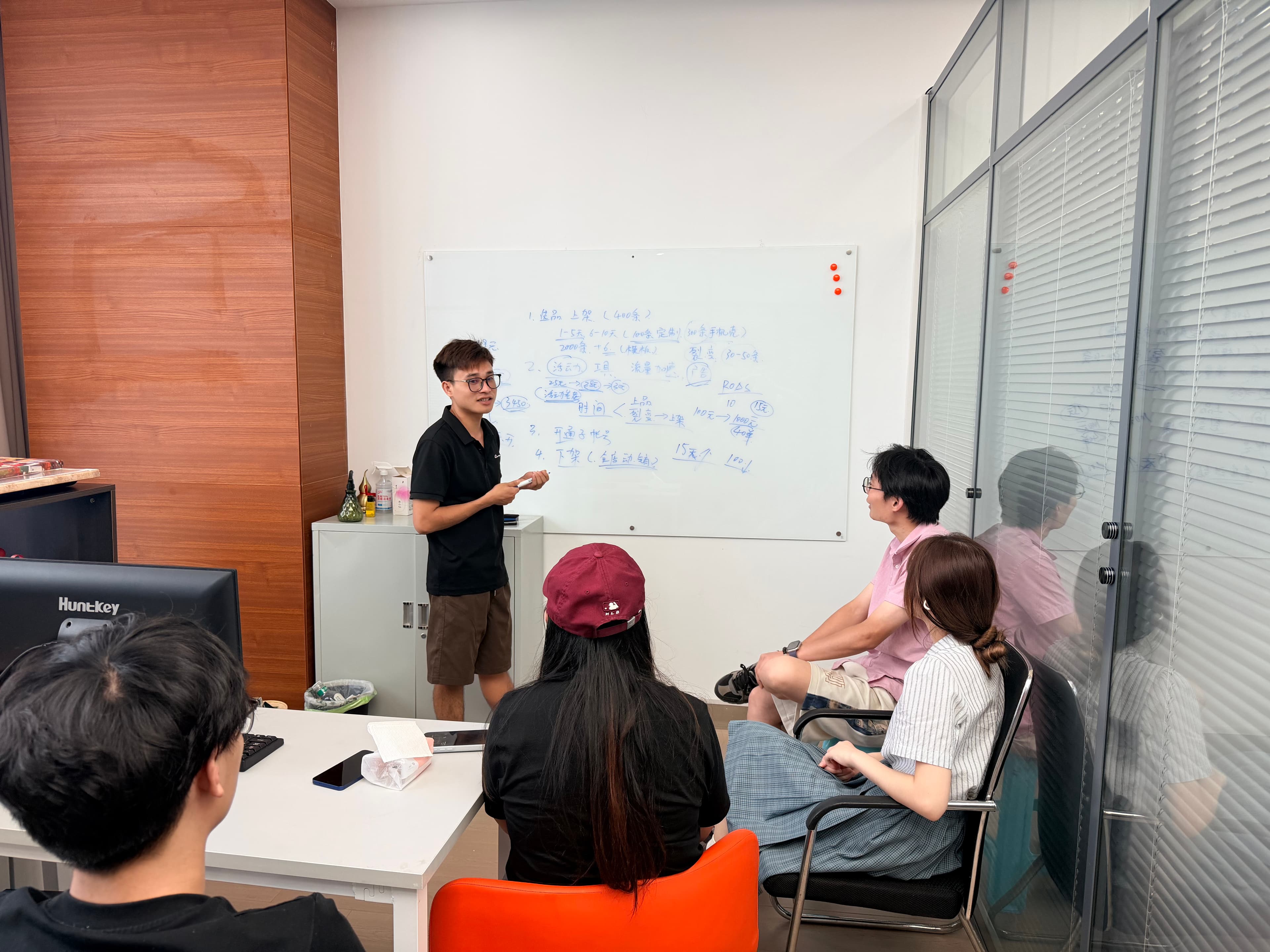 PODJST team reviewing a product plan around a whiteboard